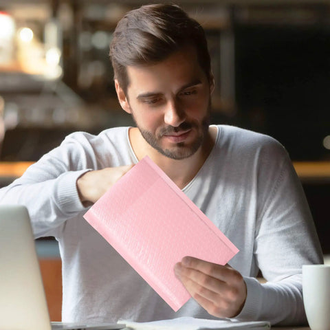 Man holding 6X10 Inch Light Pink Bubble Mailers 25 Pack Self Seal Padded Poly Mail Bags For Small Business Chic Opaque Matte Shipping Envelopes