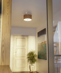 Shaker 3 Light Flush Mount Fixture In Brown Finish with blackened bronze frame and woven wood detailing in hallway.