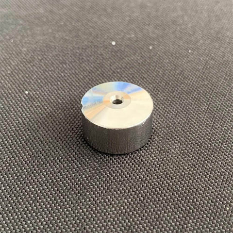 Waterjet check valve seat, cylindrical metal part with central bore; silver top, dark body