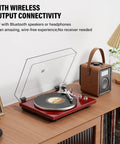 Cool Red Belt Drive Turntable For Vinyl Records With Bluetooth Output Connection Compatible With Active Speakers and Wireless Headphones on a wooden desk.
