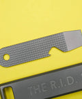 Ultra Slim Pry Bar Keychain Tool Pocket Titanium Multitool For Everyday Carry with smooth grips on yellow background