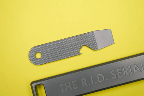 Ultra Slim Pry Bar Keychain Tool Pocket Titanium Multitool For Everyday Carry with smooth grips on yellow background