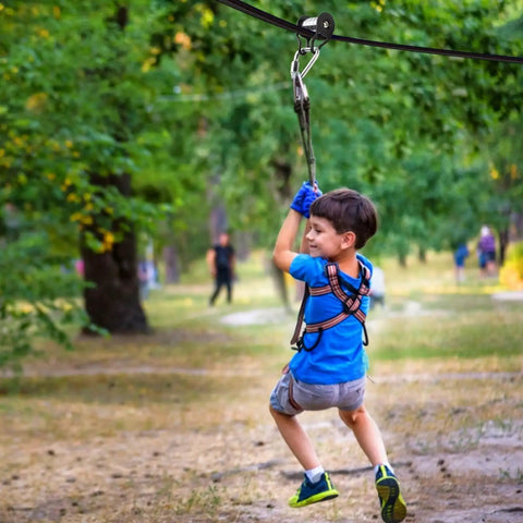 Child using Backyard Zip Line Slider For Obstacle Course With 440 Pound Capacity Smooth Glide Durable Outdoor Toy in park