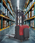 Heavy Duty Electric Pallet Stacker Forklift Powered Warehouse Lift Truck in busy warehouse aisle with stacked pallets.