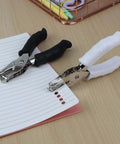 Two One Quarter Inch Circle Hole Punchers with soft grip handles in use on lined paper, ideal for crafts and office projects.