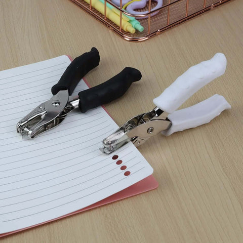 Two One Quarter Inch Circle Hole Punchers with soft grip handles in use on lined paper, ideal for crafts and office projects.