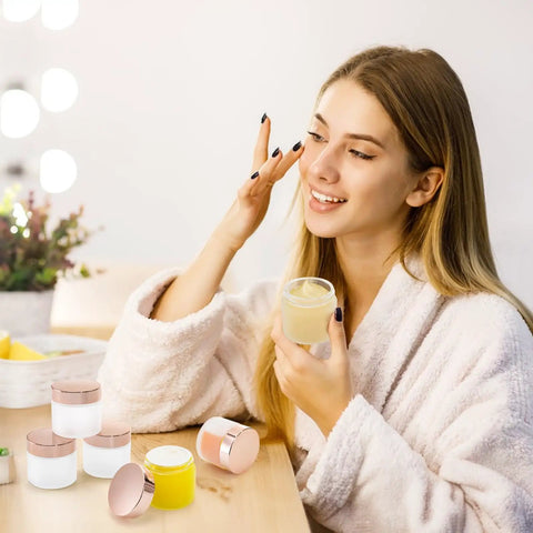 Score 16 Fresh 2 Oz Frosted Glass Sample Jars With Sleek Rose Gold Screw Caps and Tight Inner Liners with a woman applying lotion.
