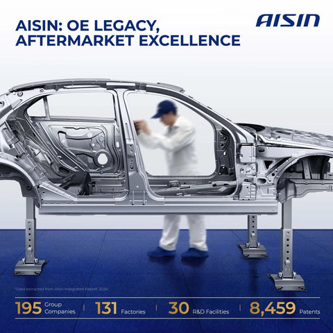 Automobile chassis with engineer in background at Aisin facility, highlighting OE legacy and aftermarket excellence.