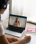 Person on video call with pink office desktop stapler with 25 sheet capacity and holds up to 120 staples next to laptop
