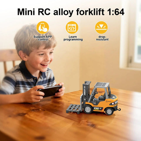 Boy playing with Mini RC Forklift Toy With App Control And Remote, 1:64 alloy crane on table, smiling, indoors.