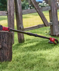 Solid Build Cordless Pole Saw With Eight Inch Bar And Ten Foot Reach To Clear High Limbs Like A Pro resting on a tree stump in the yard.