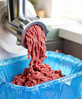 Fresh ground meat falling into a blue 60 Pack Disposable Meat Lug Liners 2.5 Mil Thick Polyethylene Bag for sanitary handling.
