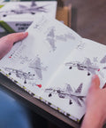 Hands holding Build Your Own Fighter Jet Erector Set Metal Model Airplane Kit instruction manual for STEM projects