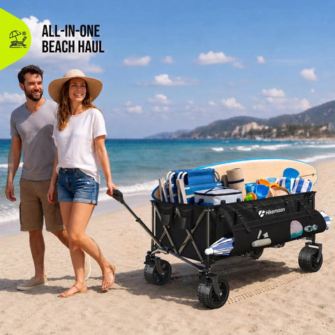 Couple pulling 400L Ultra Large Collapsible Wagon with big wheels on beach, filled with beach gear, all-weather black finish.