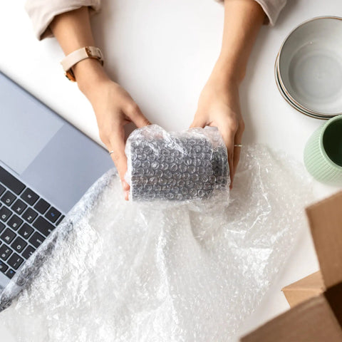 Person wrapping item using Bubble Cushioning Roll, 72 Ft Long, 12 Inch Wide, Three Sixteenth Inch Air Bubbles, Perforated Every 12 Inches