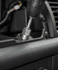 Close-up of a Smooth Operator 65 Piece Bolt Extractor Kit in use with a power drill on a vehicle's interior.