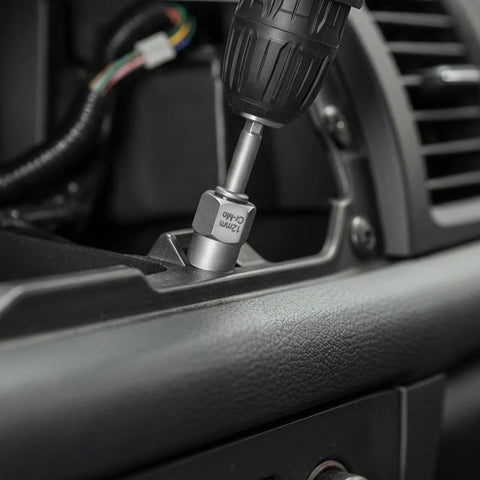 Close-up of a Smooth Operator 65 Piece Bolt Extractor Kit in use with a power drill on a vehicle's interior.
