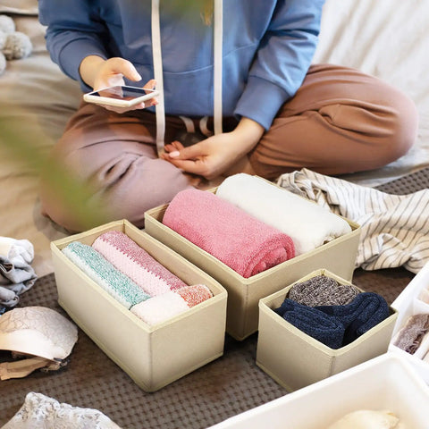 6 Piece Underwear Drawer Organizer Set Features Fold Flat Storage Bins featuring rolled towels in beige bins on a bed.