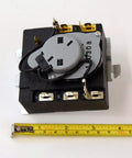 Dryer Timer WE04X25280 Genuine Replacement Part For Dryers with visible wiring and ruler for scale.