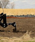 Middle Buster Furrower Attachment For Subsoil Work From Impact Implements in action, breaking hard ground in a field.