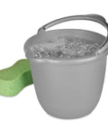 10 Qt Titanium Spout Pail Mop Bucket With Pour Spout And Comfort Grip Handle filled with water beside a green sponge