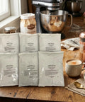 Creamy Instant Chai Latte Powder Mix For Hot Or Iced Drinks, Sweet Spiced Black Tea Latte With Milk And Honey packs on table
