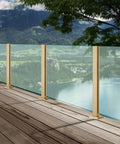 Super Sleek Heavy Duty Glass Railing Assembly With Stainless Steel Posts And Clamping Hardware For 10 To 12mm Panels on a wooden deck.