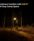 Person walking in dark forest illuminated by Upgraded Telescopic Camping Light With 15600mAh Battery Rotatable Lantern.
