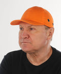 Person wearing Five Pack Reflective Bump Cap Hard Hat With Breathable Lightweight Safety Cap For Men And Women Adjustable Size With Hook And Loop Twill Neon Orange High Visibility