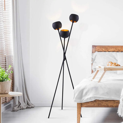 Tripod Floor Lamp In Matte Black With Three Globe Heads And Intertwining Legs Dope Modern Mid Century Style next to a bed