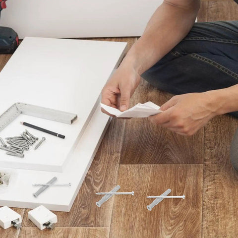 Heavy Duty Drywall Anchor Kit With Nylon And Iron Expansion Tubes For Secure Shelving And Coat Racks On Hollow Walls, Easy Install, Versatile Wall Fixings For Cabinets And Heavy Loads. man with drywall anchors and screws on floor