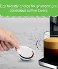 Hand placing Coffee Pod Paper Filters For Nespresso VertuoLine Brewers Use With Reusable Caps To Refill Your Own Coffee Capsules Pack Of 100