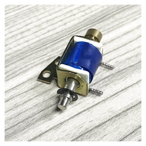 12V DC Solenoid Electromagnet Push Pull Type Linear Motion Magnet with 3mm mounting hole, side view on wooden surface