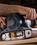 Man using Heavy Duty Sanding Belts 6X89 Inches One Twenty Grit Aluminum Oxide Abrasive Paper on wood with a belt sander.