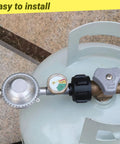 Close-up of 2 Feet Propane Hose With Regulator And Gauge For Low Pressure LP Gas Grills Patio Heaters And Fire Pits Three Eighths Inch Female Flare Fitting Brass Luminous Dial High Quality Braided Hose attached to propane tank