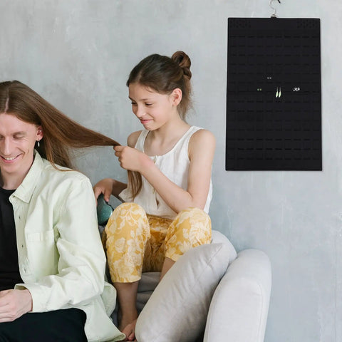 Double Sided Felt Hanging Jewelry Organizer Bag Built To Carry All Your Necklaces And Rings Slick Travel Case on wall with two people in cozy room.
