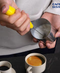 Person using Electric Coffee Milk Frother Handheld Battery Operated Drink Mixer With Stainless Steel Whisk And Stand In Bold Yellow