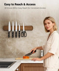 Woman using Magnetic Knife Holder For Wall And 16 Inch Acacia Wood Knife Strip, Kitchen Storage Organizer with knives and shears.
