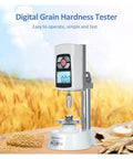 Straight Up Accurate Mini Grain Hardness Tester Meter With Crisp Digital Screen For Farm Fresh Seed Checks Quick Load Testing On Paddy Rice And Cereal Up To Twenty Kg No Fuss Portable Gauge For Down To Earth Precision on wooden table with grains in background