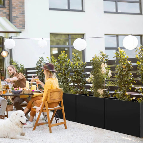 Massive Galvanized Steel Planter Box With Removable Insert Shelf And Four Drainage Holes Weather Resistant 32 Inches Long By 12 Inches Wide By 24 Inches Tall For Indoor And Outdoor Patio Porch Decor Black, installed outdoors on a patio with people dining nearby.