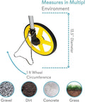 Heavy Duty Digital Distance Measuring Wheel With 12 Inch Wheel And Large LCD Display shows 12.5-inch diameter wheel measuring on gravel.