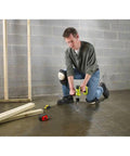 Man using Eighteen Volt Cordless Hammer Drill And Impact Driver Combo Kit on concrete floor in workshop