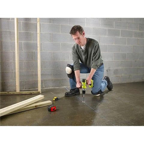 Man using Eighteen Volt Cordless Hammer Drill And Impact Driver Combo Kit on concrete floor in workshop