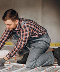 Man wearing Steel Toe Work Boots For Men Waterproof Built Tough Heavy Duty Safety Boots With Puncture Protection Oil And Slip Resistant Design Breathable Lining EH Protection For Construction And Industrial Jobs, kneeling on construction site.
