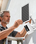 Man installing 2 In 1 Solar Panel Wall Mount For Outdoor Security Camera With 7W Solar Charger on a wall, ladder visible