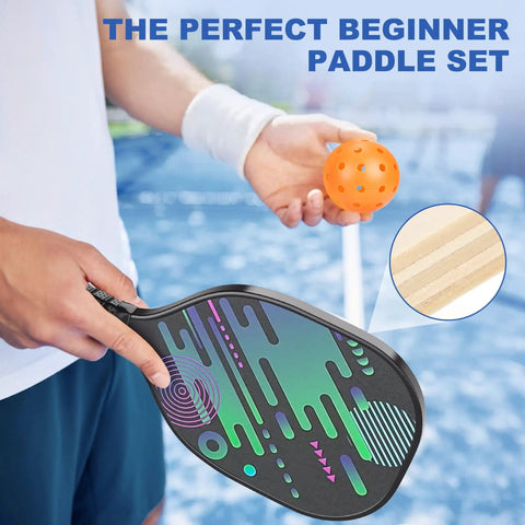 Person holding a pickleball paddle with a graphic design and an orange ball, focus on "All In One Pickleball Net Set On Wheels For Driveway Or Backyard With 22 Foot Regular Size Includes 4 Paddles 6 Balls 12 Court Markers And A Durable Carry Bag For Indoor Outdoor Play".