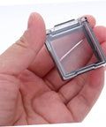 Close-up of a hand holding a 26mm Button Switch Dustproof Cover with Double-Sided Adhesive, clear plastic design for PC and appliances.