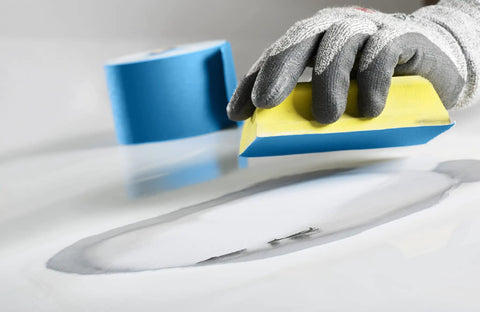 Gloved hand using Stikit Blue Abrasive Sheet Roll 600 Grit For Auto Body Repair Pro Grade Long Lasting Ceramic Mineral Blend