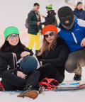 Group of people in winter sports gear, one wearing a black 2 Pack 3 Hole Full Face Mask Balaclava Ski Mask For Winter Outdoor Sports Soft Polyester Cotton Face Cover