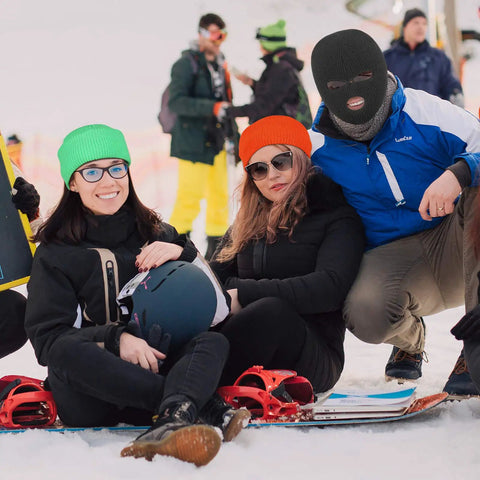 Group of people in winter sports gear, one wearing a black 2 Pack 3 Hole Full Face Mask Balaclava Ski Mask For Winter Outdoor Sports Soft Polyester Cotton Face Cover
